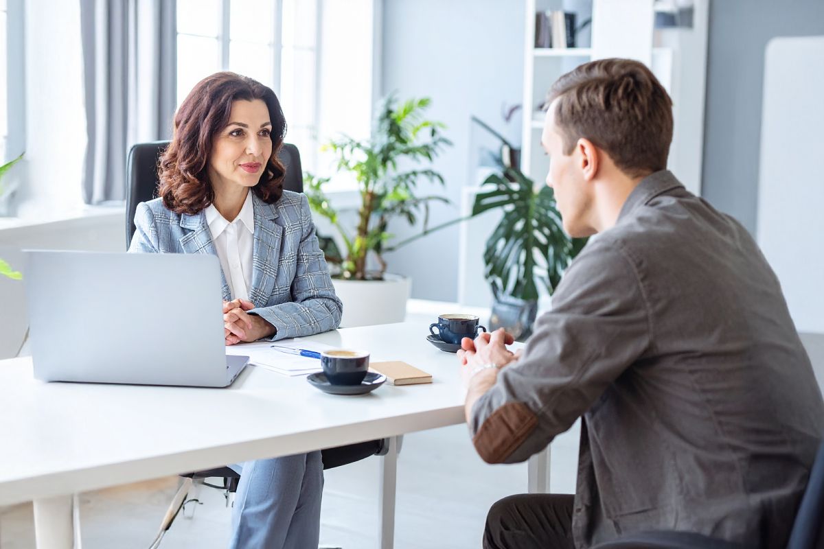 femme assis devant un table qui écoute son collaborateur
